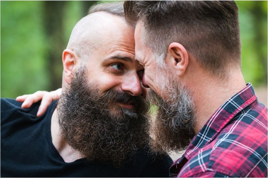 Two men laughing together in golden hour park light